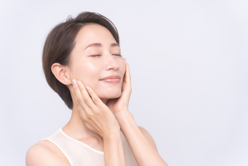 頬に手を当てて笑顔の女性