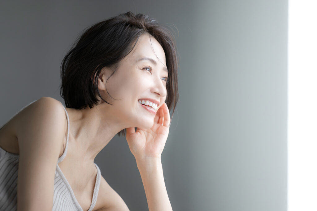 窓際を笑顔で見つめる女性