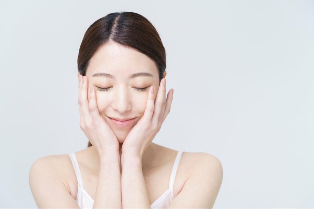 頬に両手を当てている女性