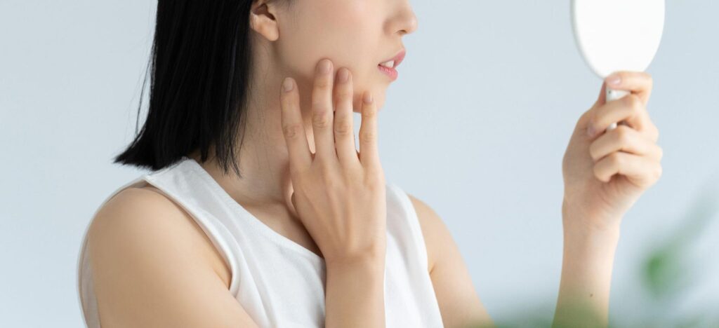 ヒアルロン酸施術後に鏡を見て効果を確かめている女性