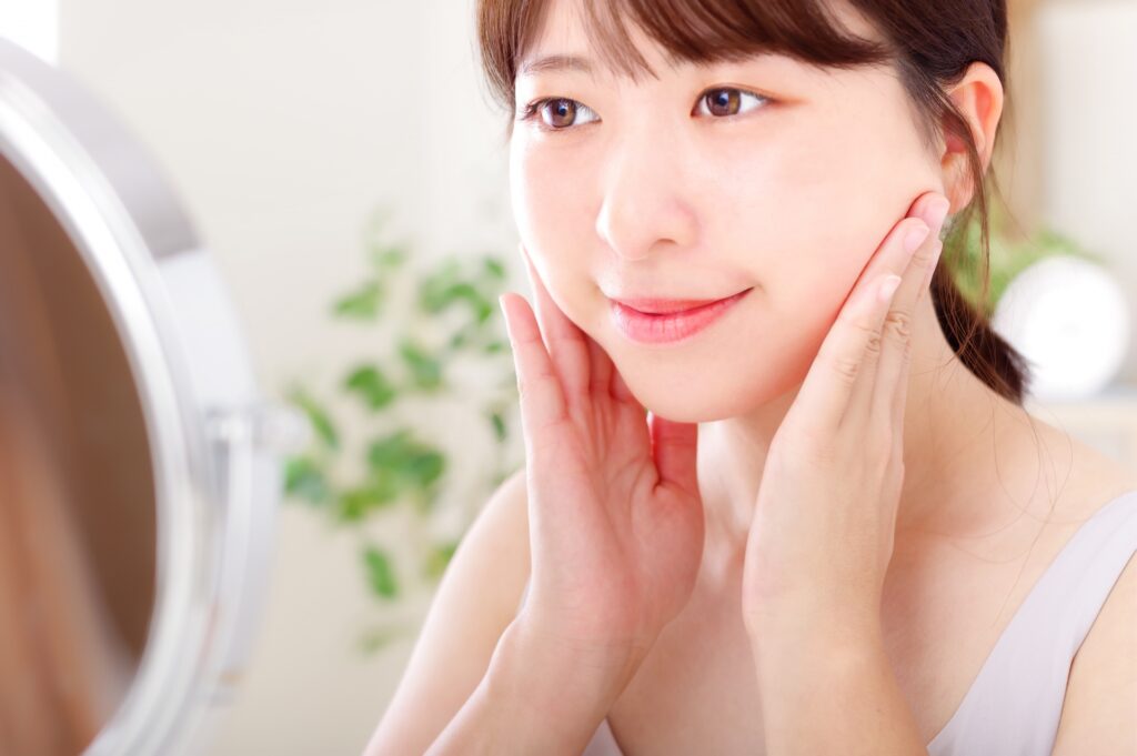 頬に手を当てて笑顔の女性