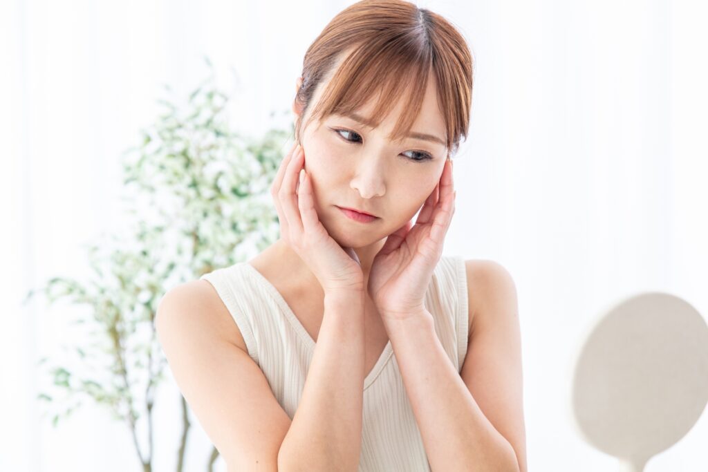 頬に手を当てて浮かない表情の女性