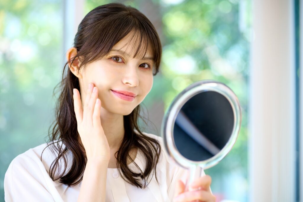 鏡を持って笑顔の女性