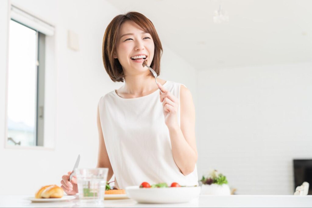 笑顔で健康的な食事をしている女性