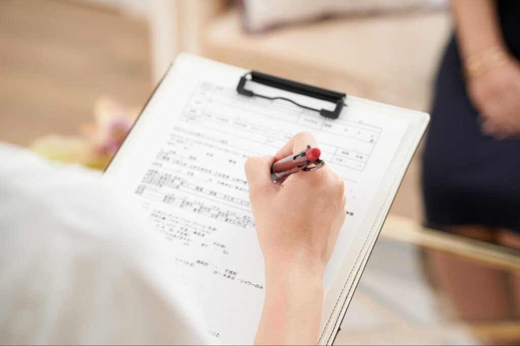 カルテに記入する手元