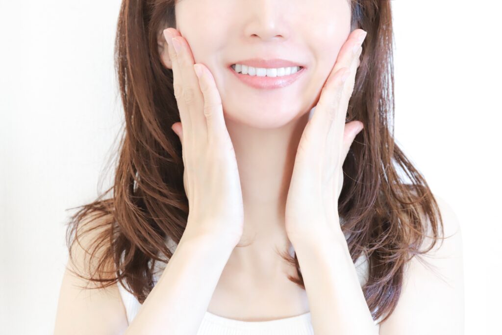 頬に手を当てて笑顔の女性