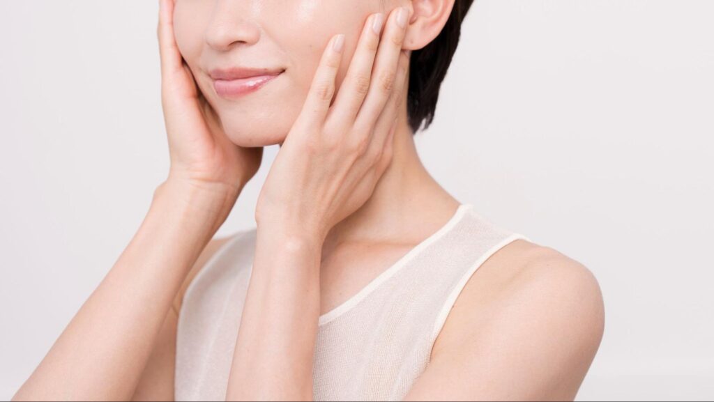頬に手を当てている美肌の女性