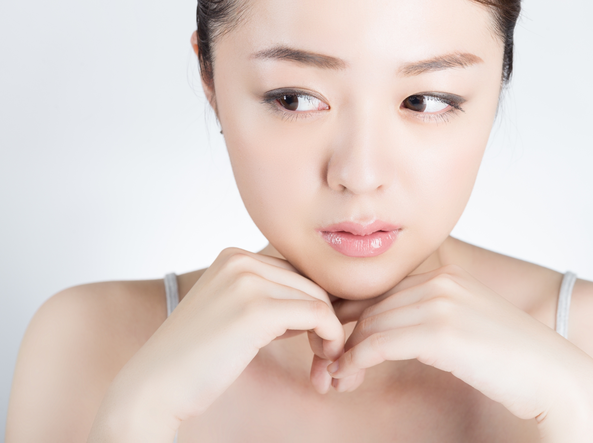 両手を顎に添えた女性