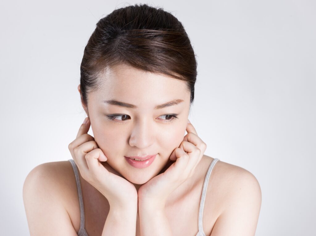 両手で頬杖をつく女性