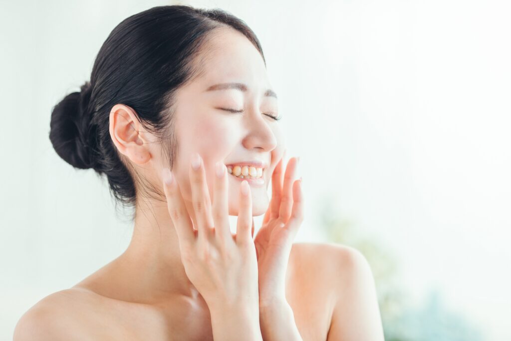 頬に手を当てて笑顔の女性