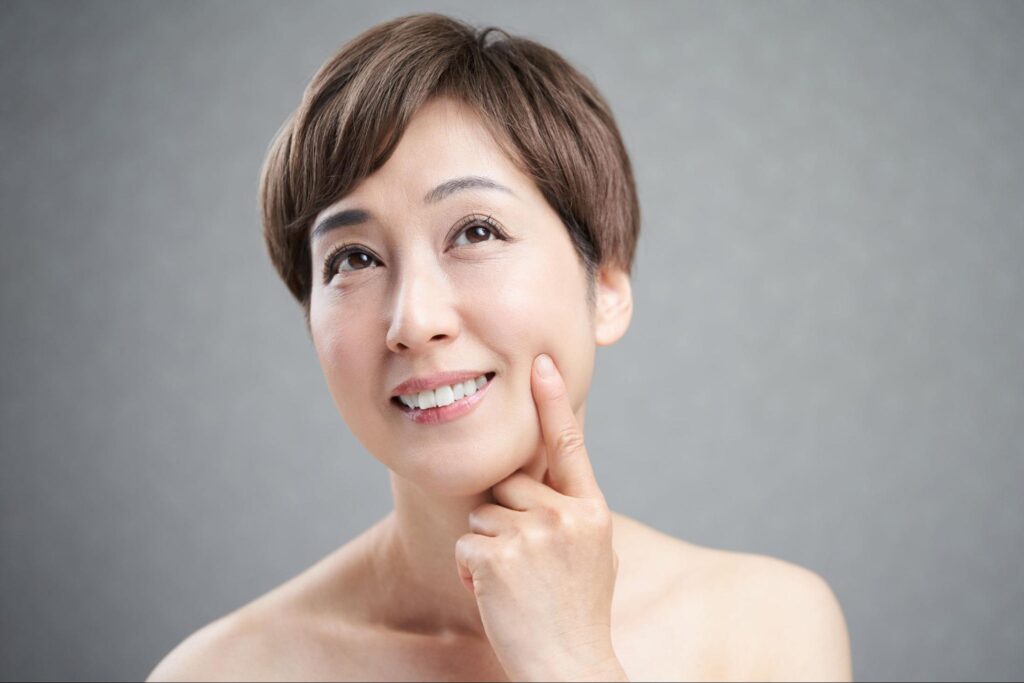 頬に指を当てている女性