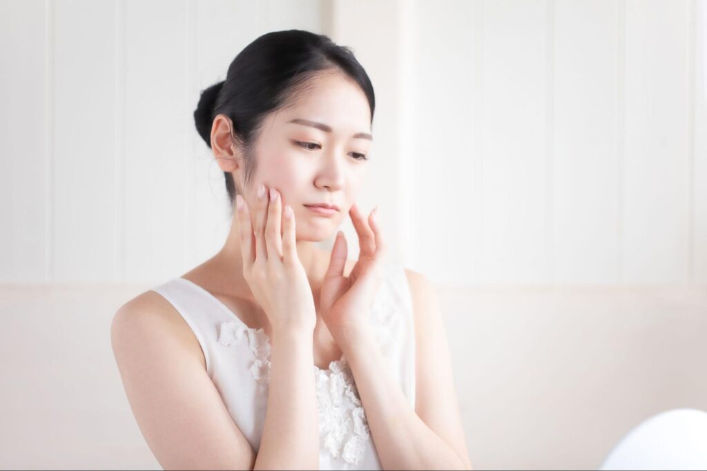 頬に手を添えて浮かない顔の女性